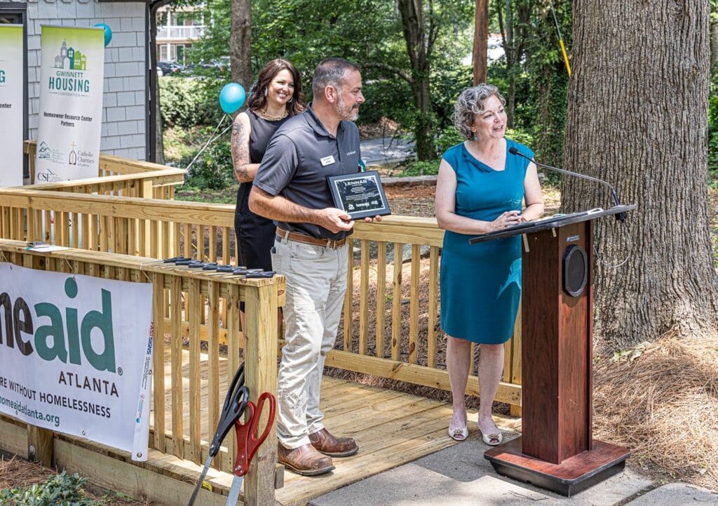 HomeAid Atlanta Executive Director Mandy Crater presents Adam Paterson with a plaque to thank Lennar for the homebuilder's role as Builder Captain.