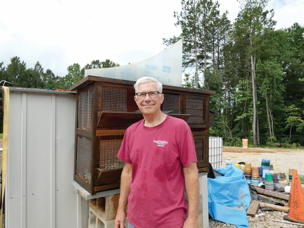 Robert Fugate stands in front of the bird box he has been helping
construct