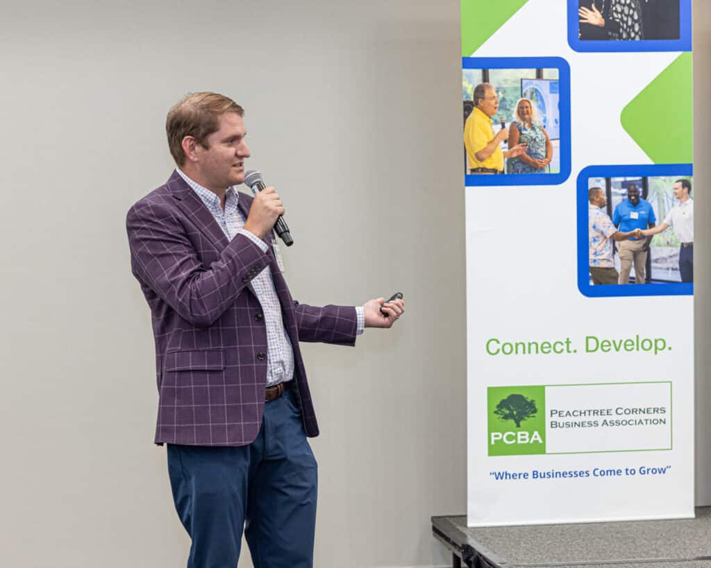 Man in purple blazer speaking at a business event