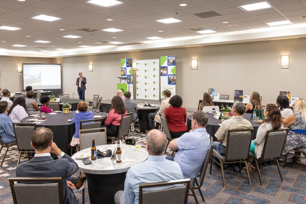 Alex Urban speaking in front of a group of people