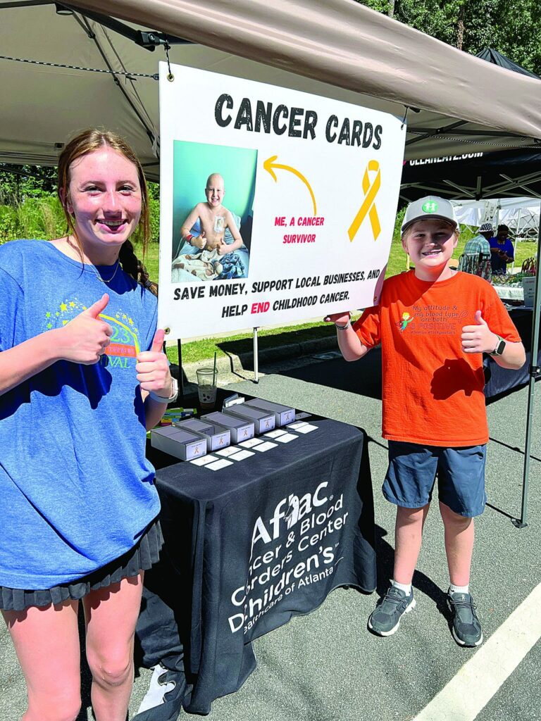 Two people manning a fundraising booth outdoors