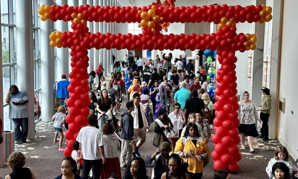 crowd of people walking through a large red arch at JapanFest