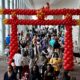 crowd of people walking through a large red arch at JapanFest