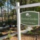 A green sign with white lettering and white post for the Debbie Mason Overlook Garden in Peachtree Corners