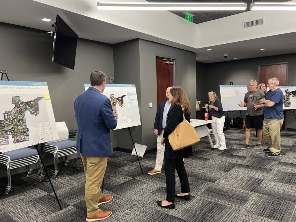 people talking and looking at map displays at a city meeting