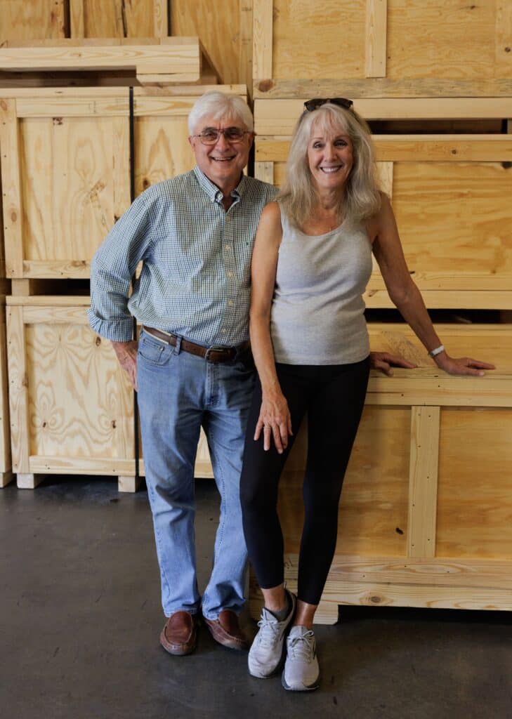 two people from Reid Packaging standing in front of crates and boxes in a warehouse