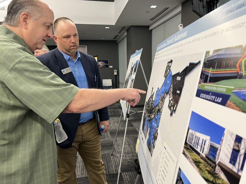 two men looking at a map display at a city meeting