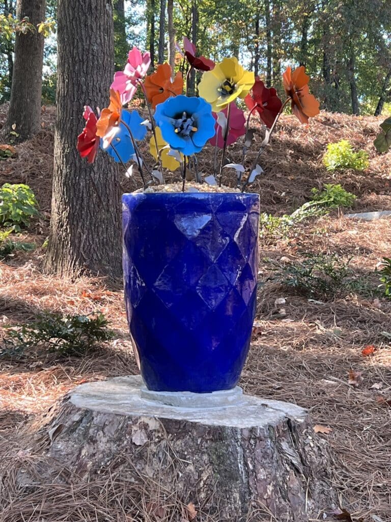 Large blue vase with colorful faux flowers at the Debbie Mason Memorial Garden