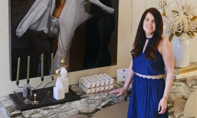 Woman in blue dress standing in front of painting