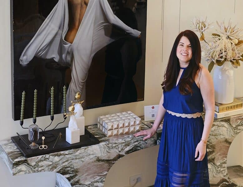 Woman in blue dress standing in front of painting