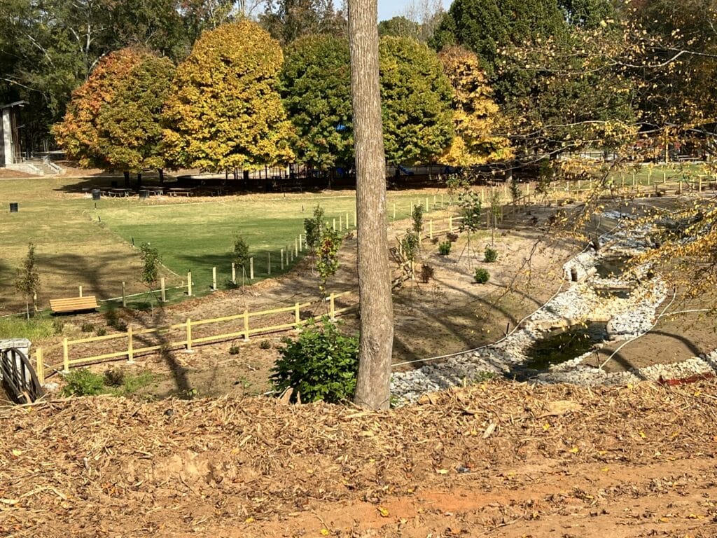 A bench in a field where work is being done at Jones Bridge Park