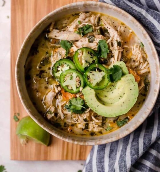 bowl of white chicken chili topped with jalapenos and avocado