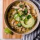 bowl of white chicken chili topped with jalapenos and avocado