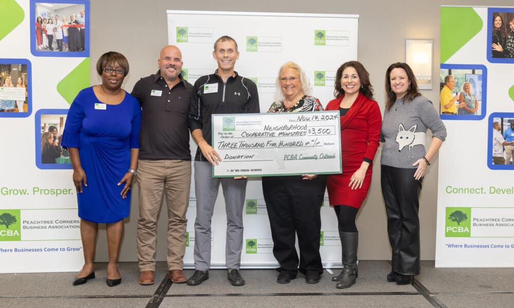 A group of people from PCBA and NCM holding an oversized check for $3500