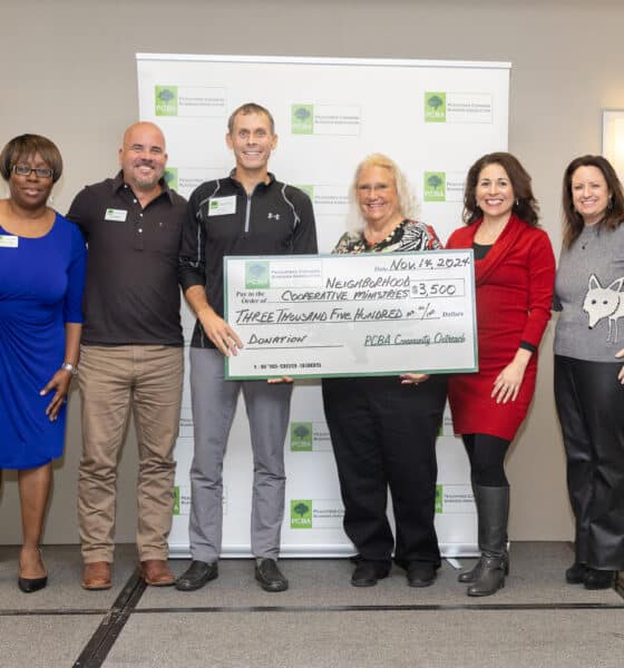 A group of people from PCBA and NCM holding an oversized check for $3500