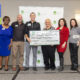 A group of people from PCBA and NCM holding an oversized check for $3500