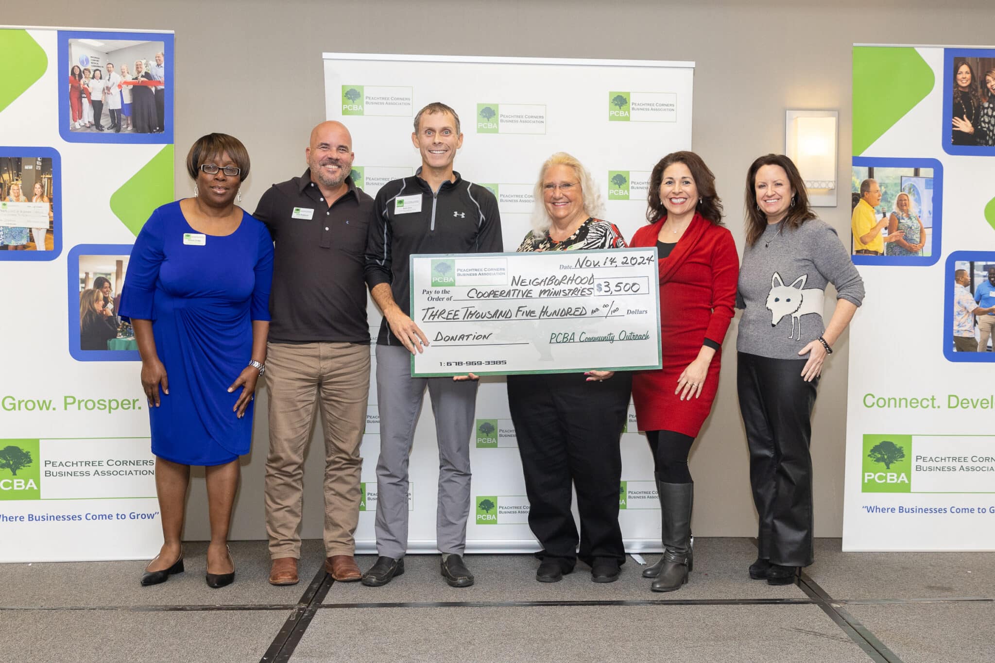 A group of people from PCBA and NCM holding an oversized check for $3500