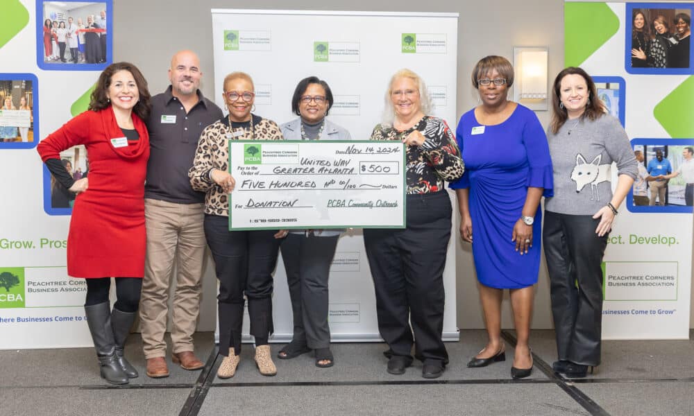 Members of the PCBA and United Way of Greater Atlanta standing together holding an oversized donation check for $500