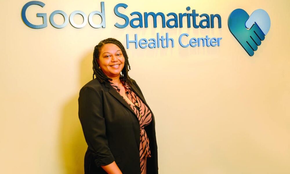 Professional woman standing in front of Good Samaritan Health Center signage