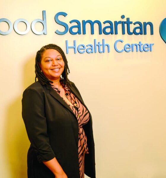 Professional woman standing in front of Good Samaritan Health Center signage