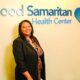 Professional woman standing in front of Good Samaritan Health Center signage