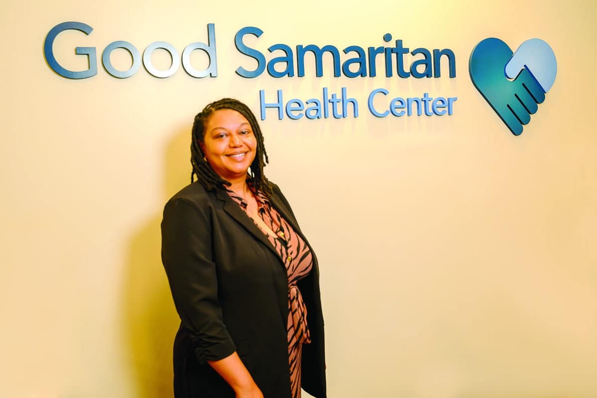 Professional woman standing in front of Good Samaritan Health Center signage