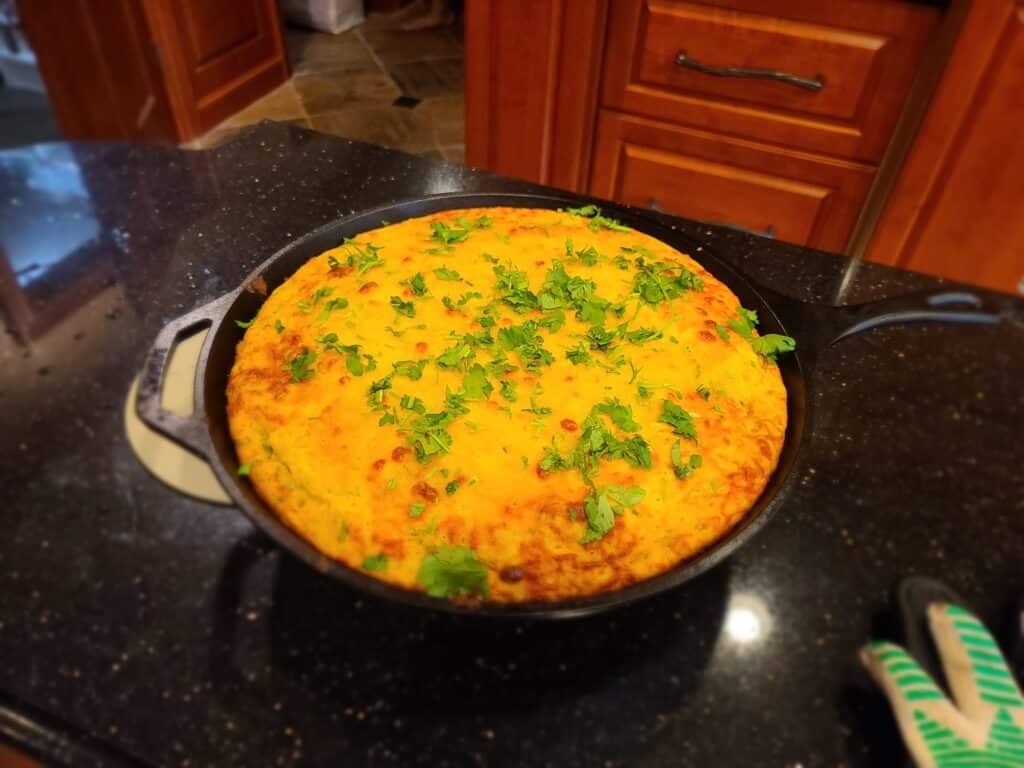 A pan of Jalapeno cornbread sitting on a black kitchen counter