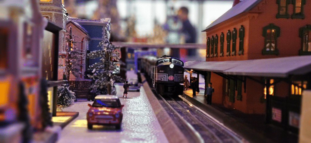 Details of a Christmas train model village with car and buildings