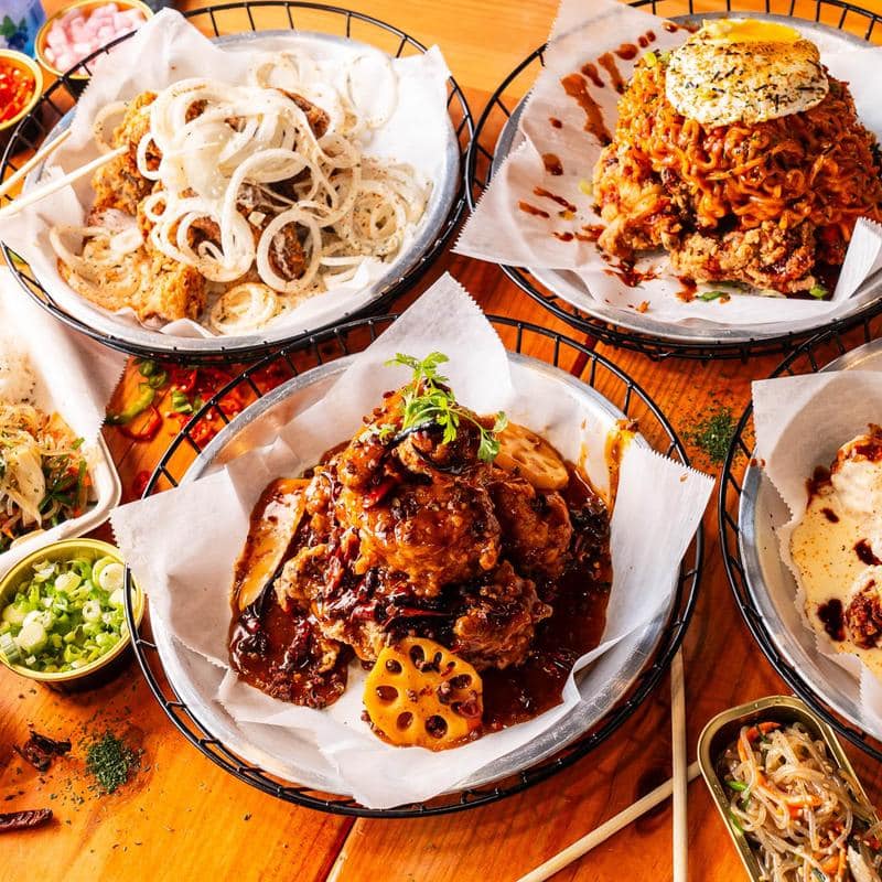 An assortment of Korean fried chicken dishes and banchan side dishes