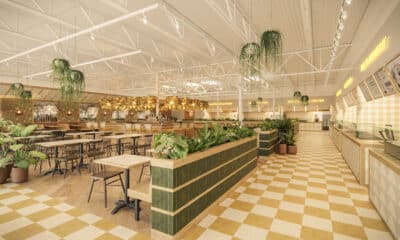 Spacious food hall with gold, white and green accents, high ceilings and checkerboard floor.