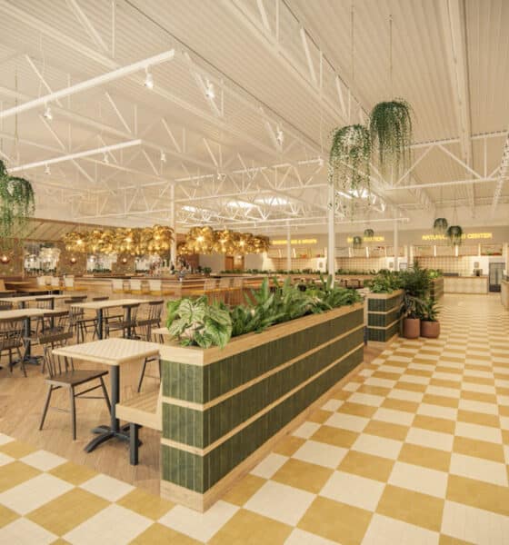 Spacious food hall with gold, white and green accents, high ceilings and checkerboard floor.