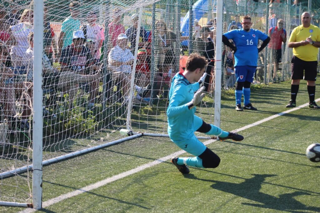 Soccer goalkeeper in blue, blocking a shot