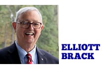 White man with white hair and glasses wearing a suit with a red tie, smiling. Beside the image is the name Ellliott Brack in all-caps blue letters on a white background.