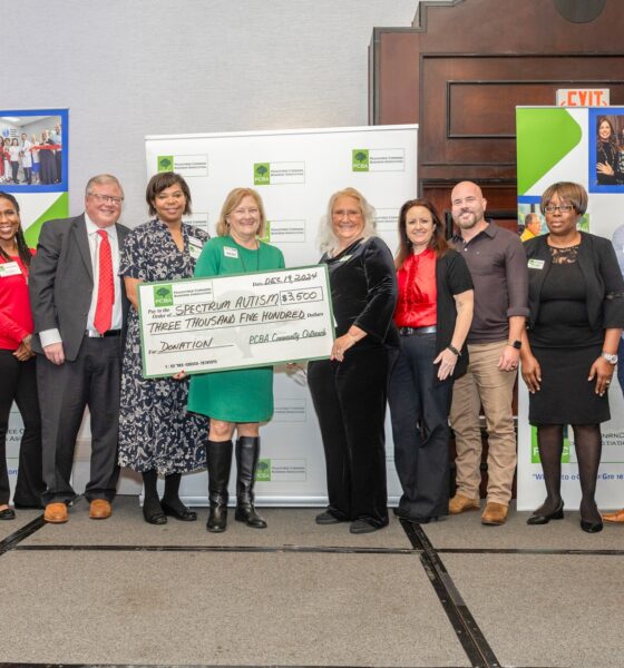 A group of people holding a large check to represent a $3500 donation from the PCBA to the Spectrum Autism Support Group