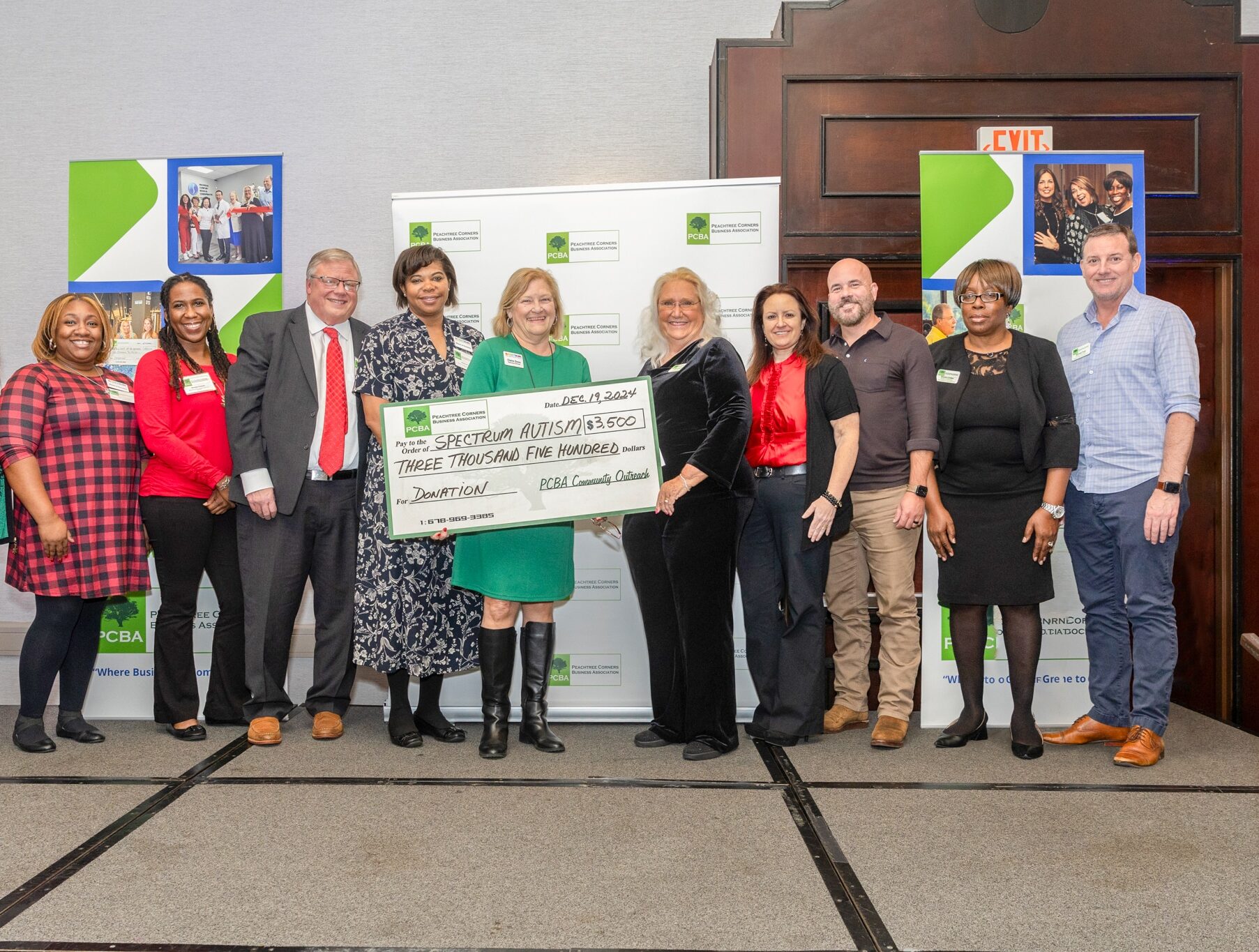 A group of people holding a large check to represent a $3500 donation from the PCBA to the Spectrum Autism Support Group