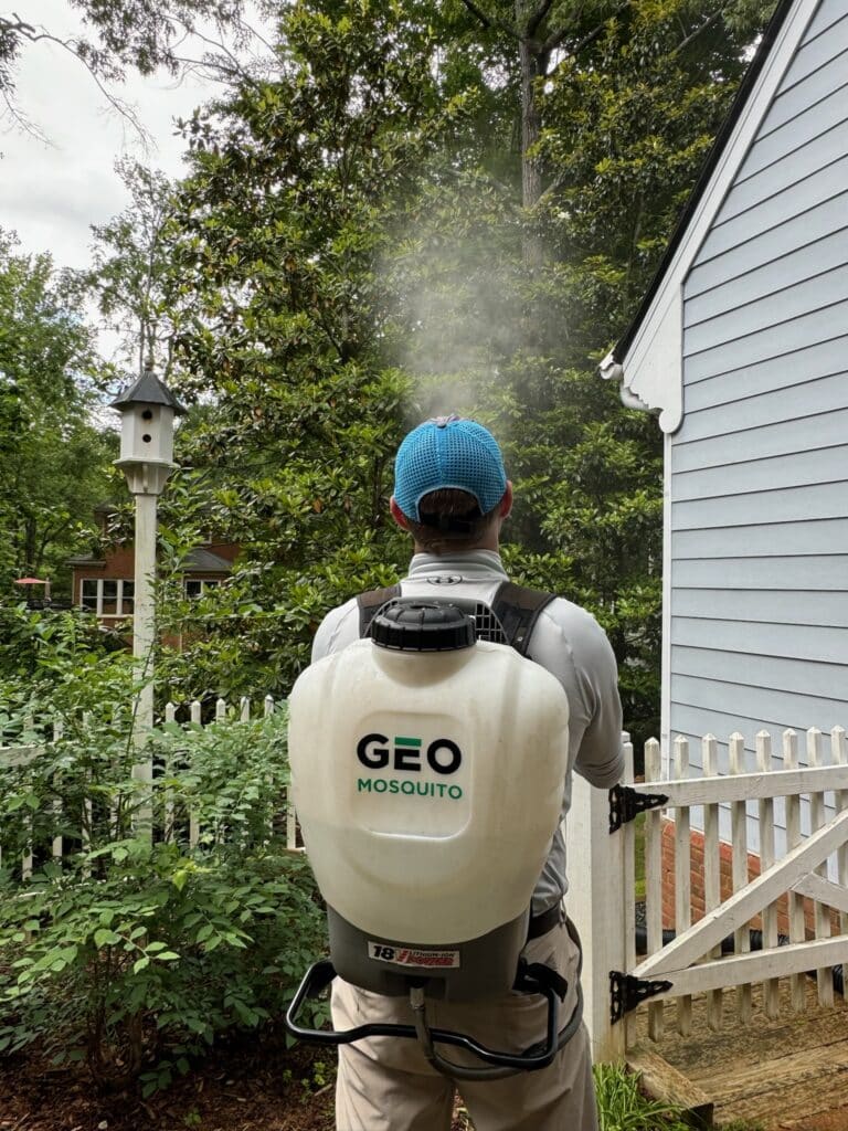 Pest control technician from Geo Mosquito spraying a customer's yard.