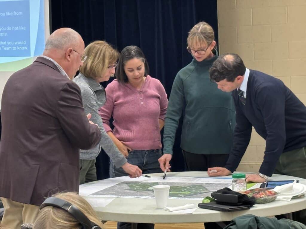 A group of people looking over proposed changes to Simpsonwood Park