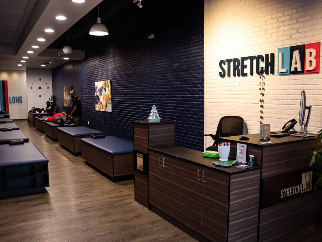 Front desk area of a StretchLab fitness center. Fitness tables can be seen in the background.