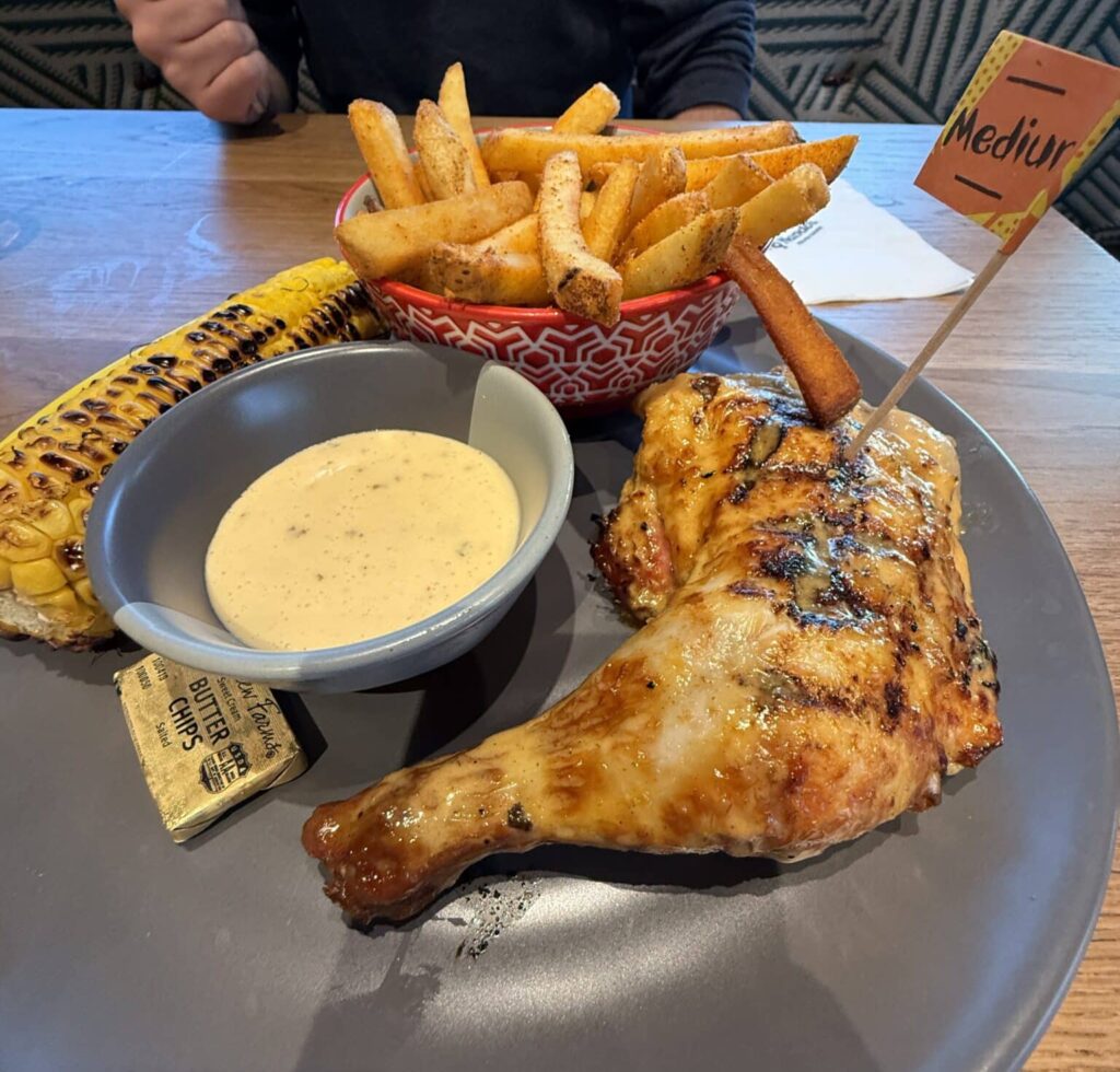 Plates of chicken, fries and sides at Nando's PERi-PERi