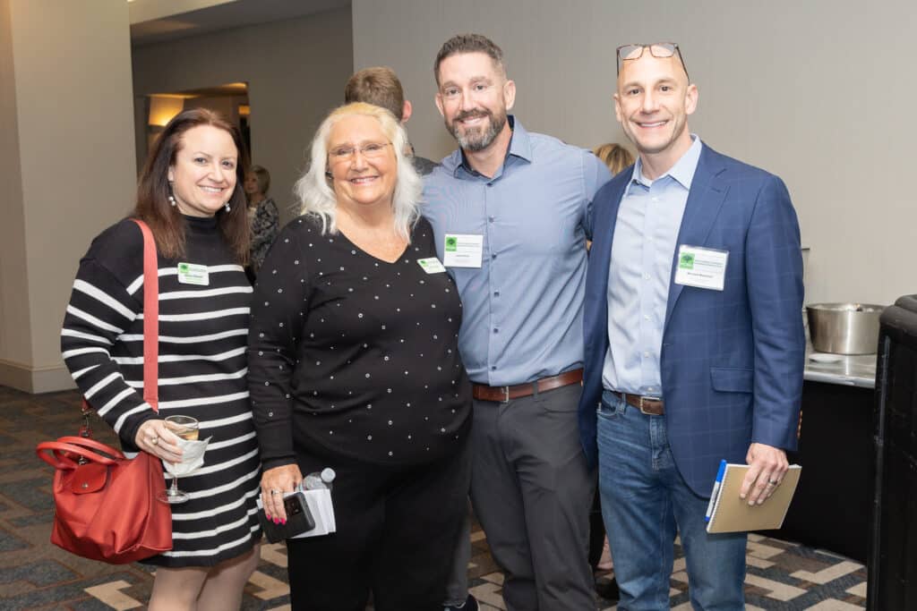 Two men and two women standing together for the photo at a business panel event