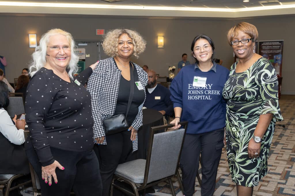 Four women standing together at a business panel event