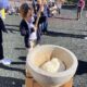 Young student pounding sticky rice with a large wooden mallet at an outdoor Japanese new year event