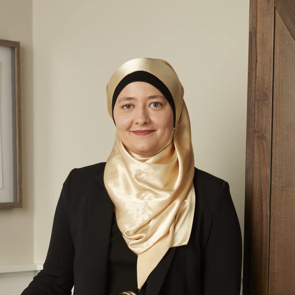 Georgia State Rep. Ruwa Romman in a gold hijab and black, long-sleeved top. 