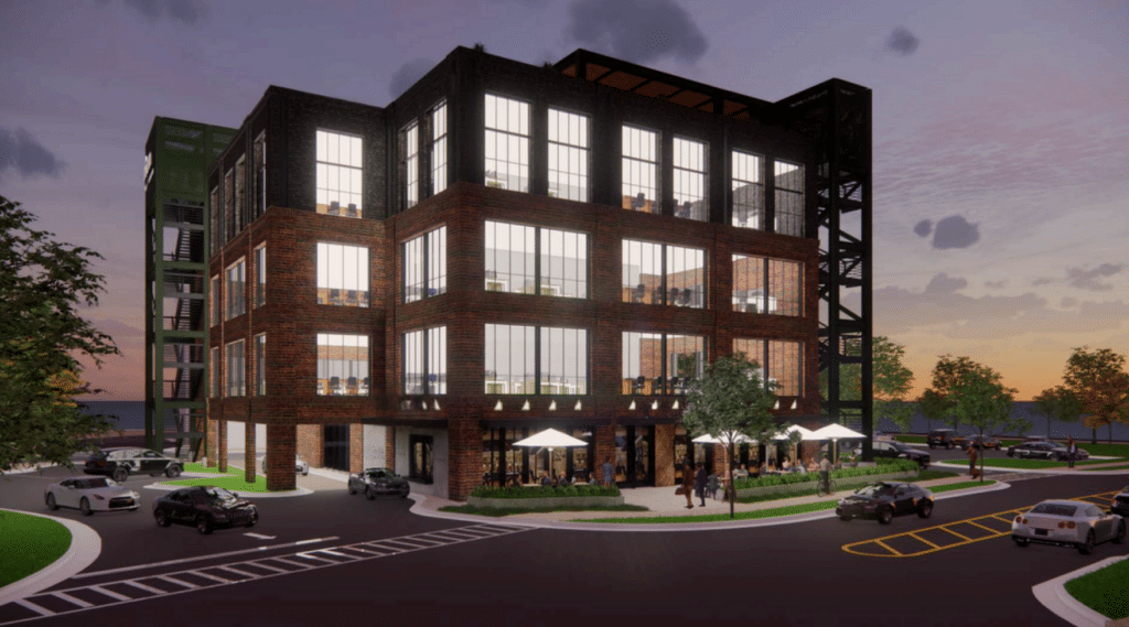 Night time rendering of the exterior of a three-story brick and glass building with roadway, green space and outdoor cafe tables.