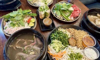 Pho and other Vietnamese dishes on a table with drinks