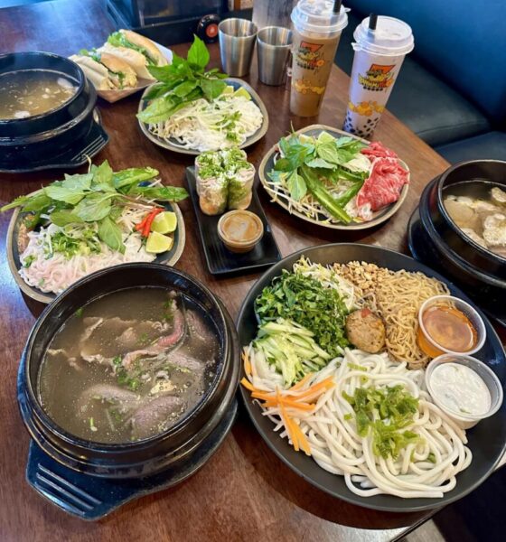 Pho and other Vietnamese dishes on a table with drinks