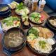 Pho and other Vietnamese dishes on a table with drinks