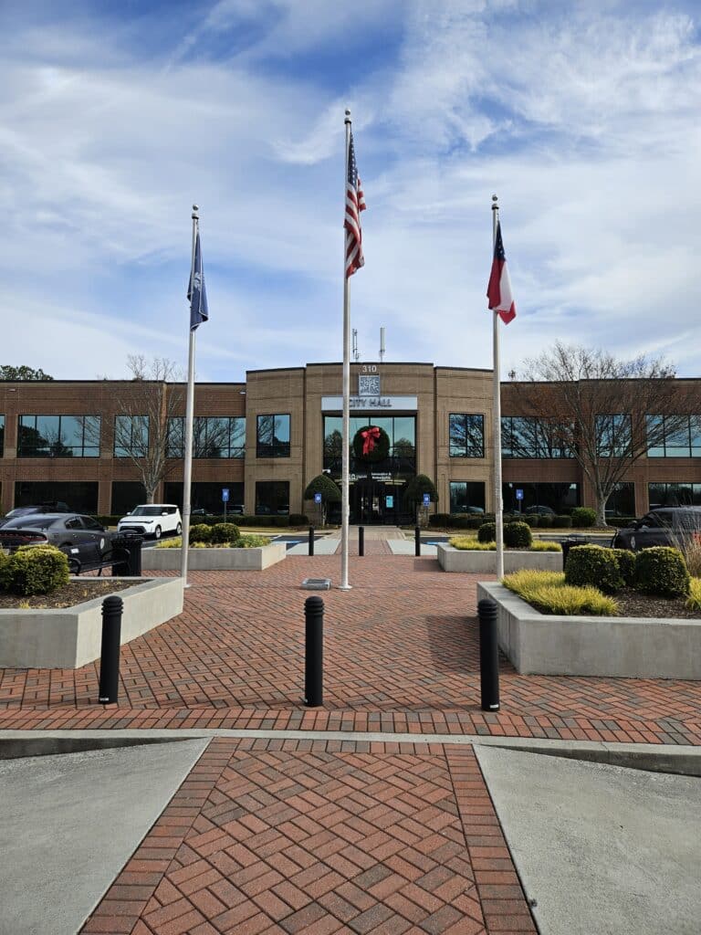 Three flags on poles in front of PTC city hall