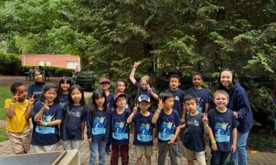 Group of children and adults wearing dark blue tshirts at an outdoor Children's Day festival in Norcross, Georgia