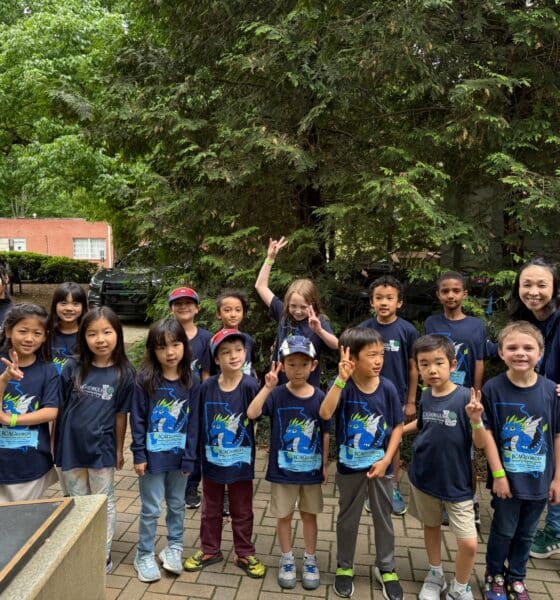 Group of children and adults wearing dark blue tshirts at an outdoor Children's Day festival in Norcross, Georgia